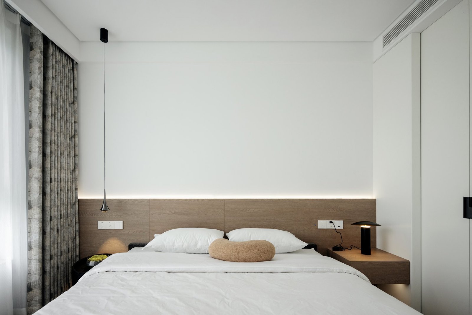 Completed main bedroom with warm timber headboard and soft neutral finishes