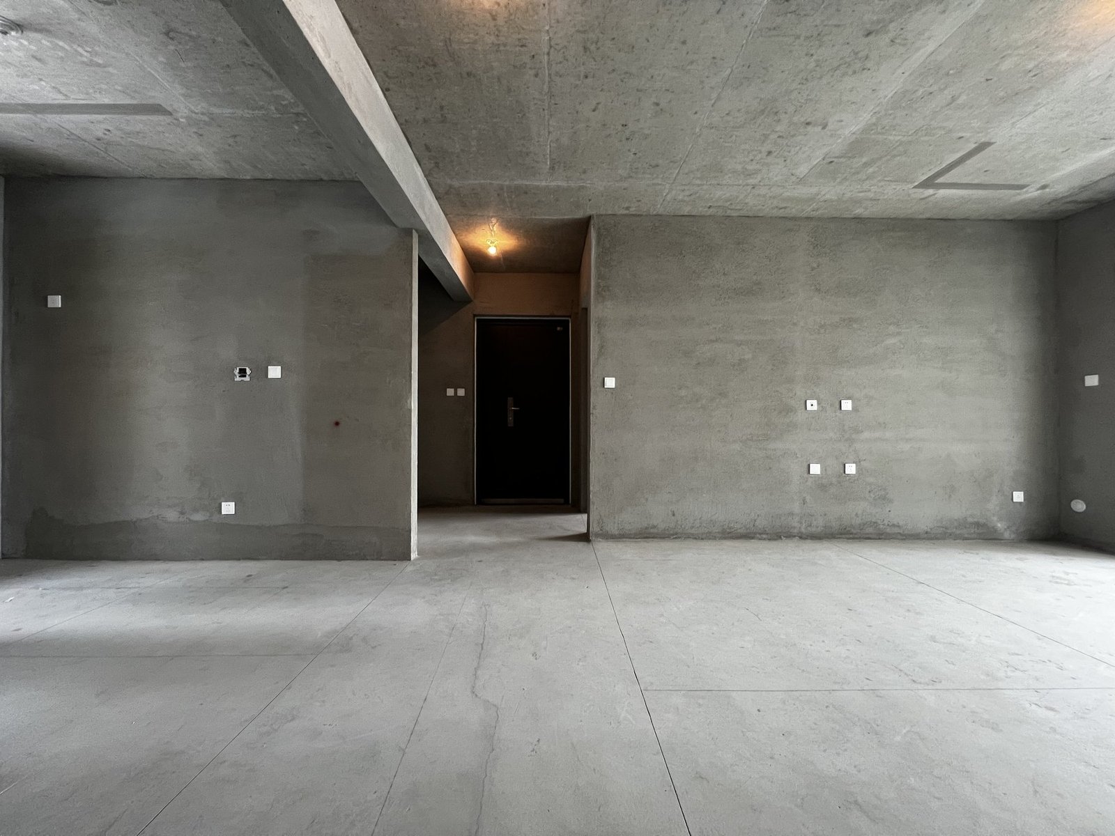 Bare-shell living and dining area before the spatial redesign