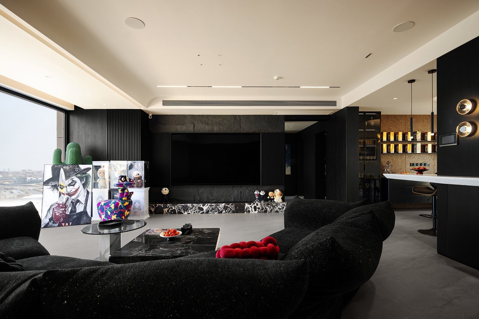 Curved black sofa positioned beside the sea-view window