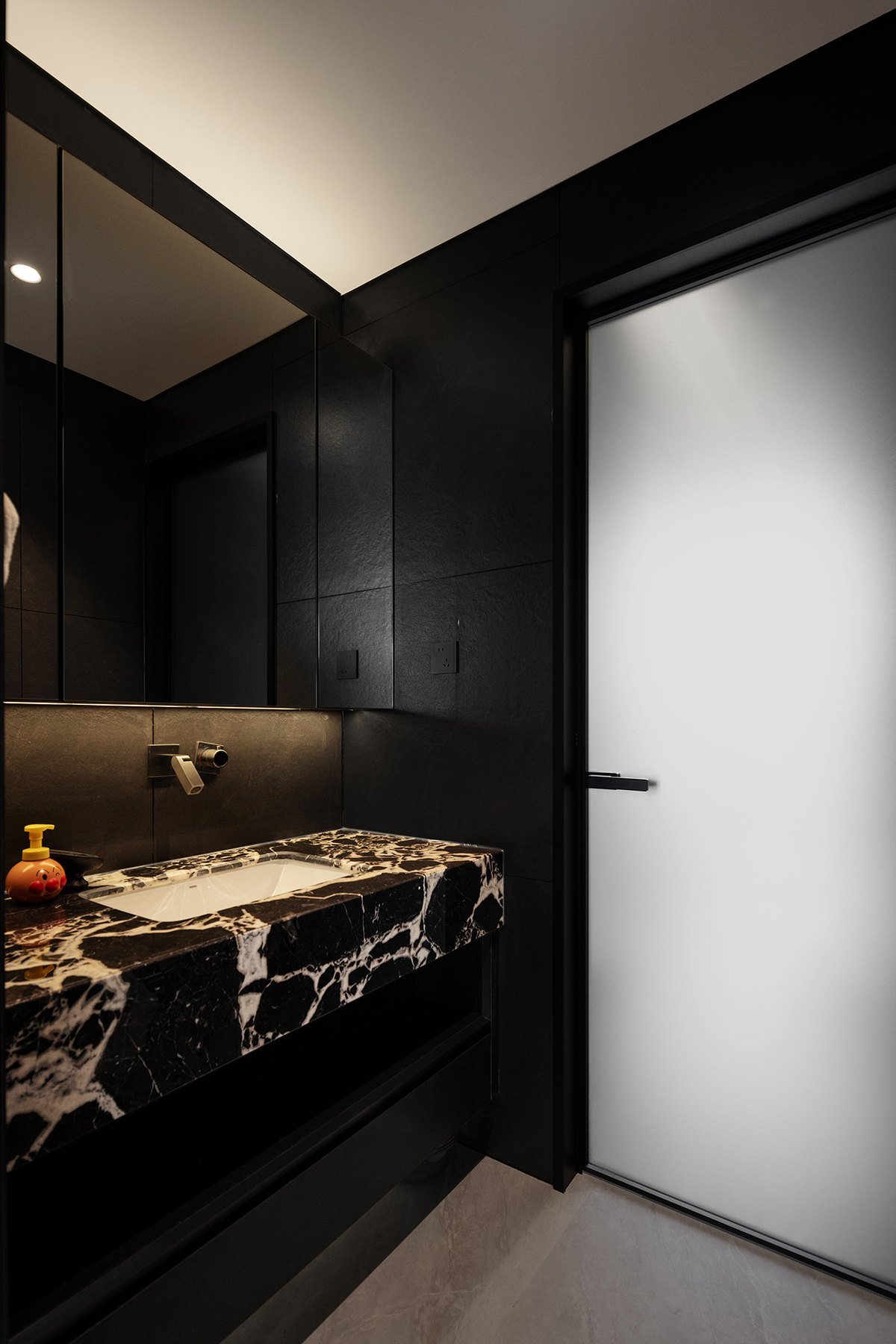 Completed bathroom with marble basin and dark surfaces