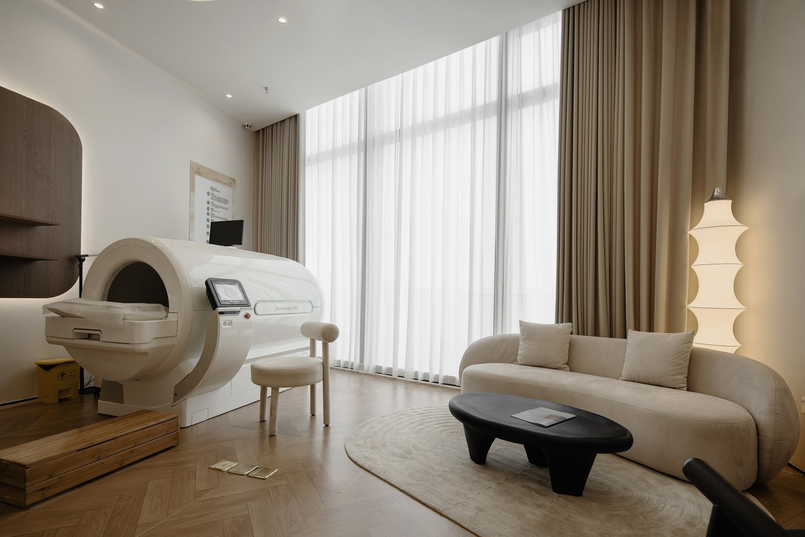 Treatment and lounge setting framed by full-height curtains and warm lighting