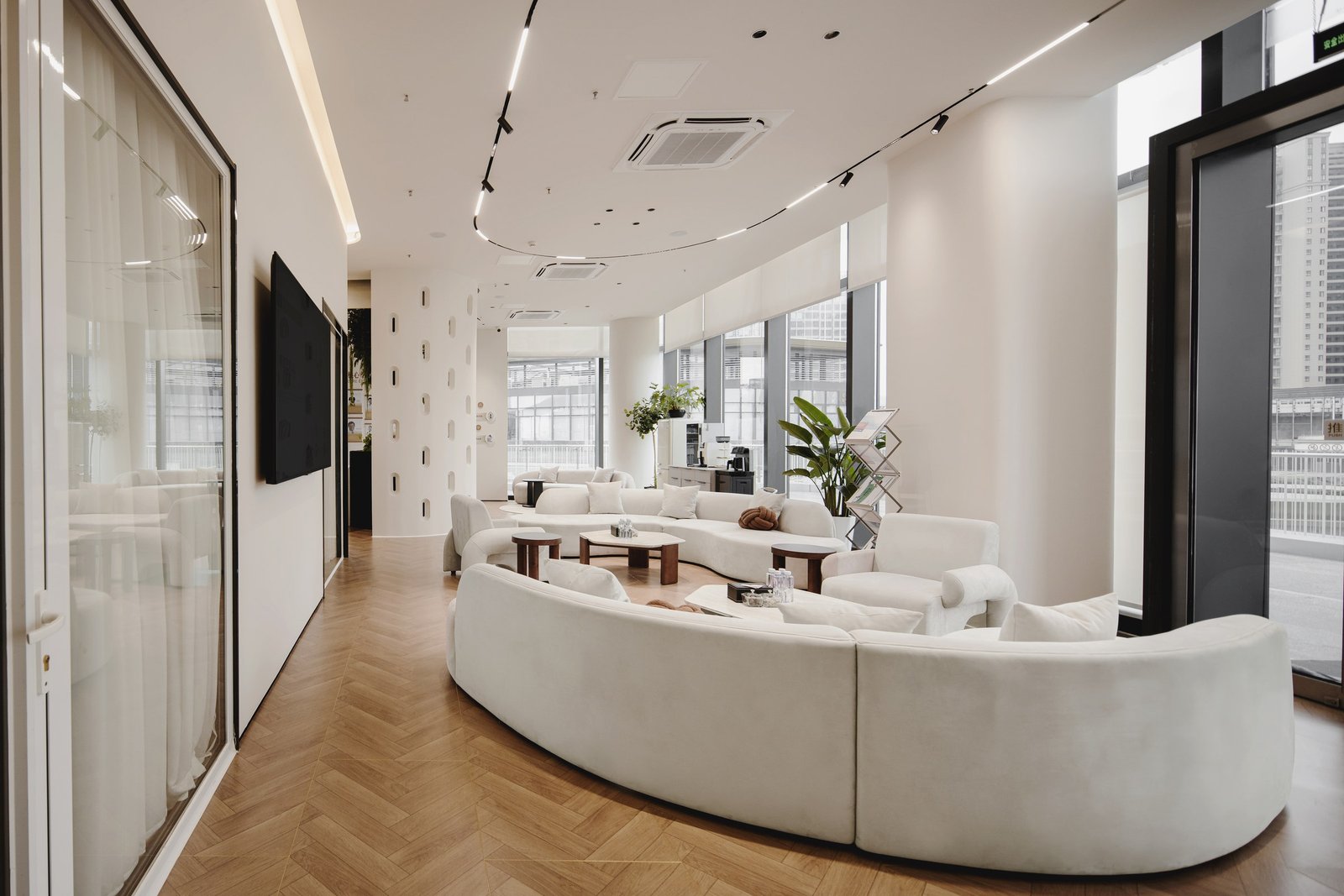 Daylit waiting lounge with curved seating and light timber flooring